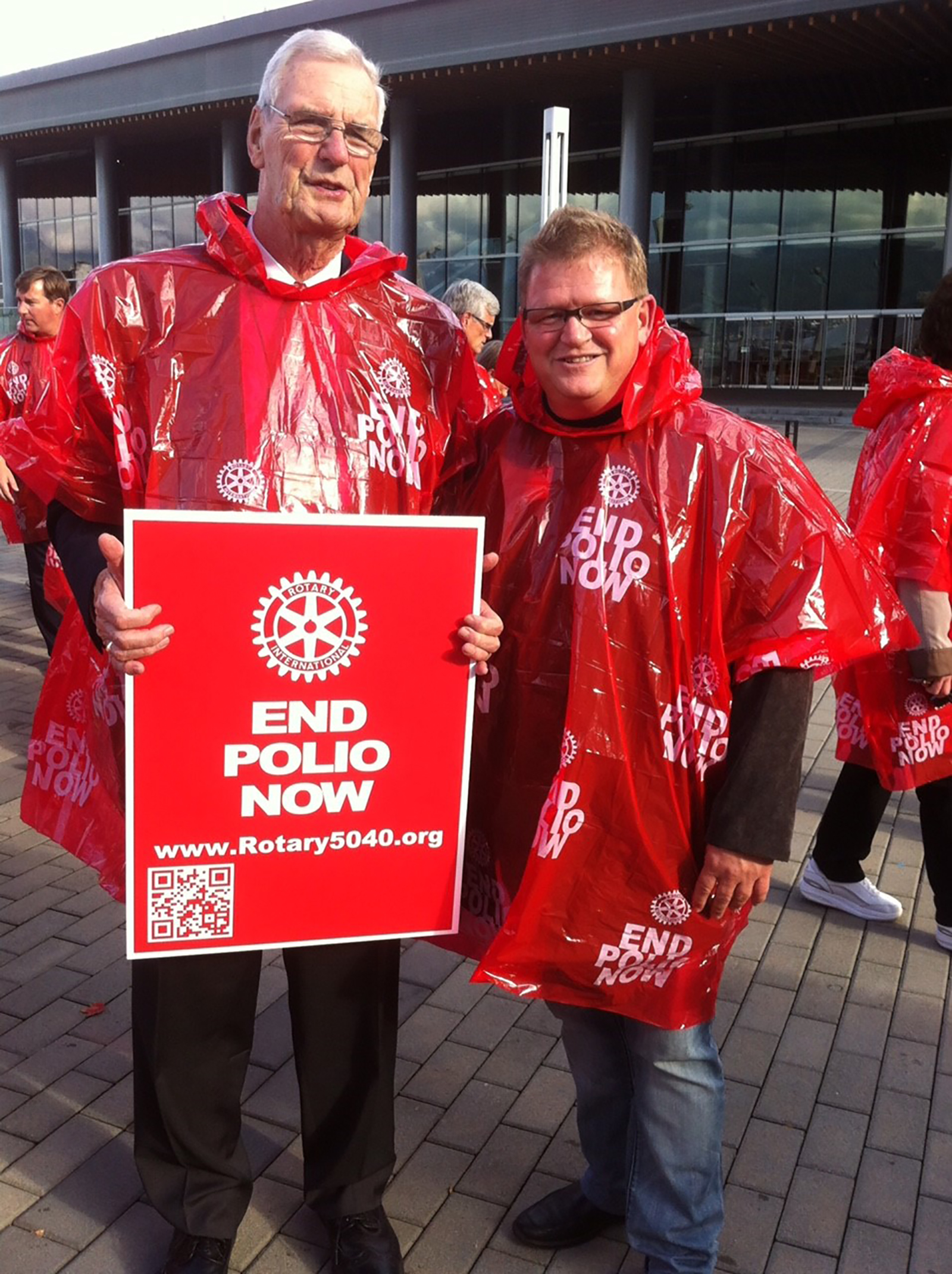 Bob Scott and Michael Kinsey don red ponchos to raise awareness on World Polio Day.