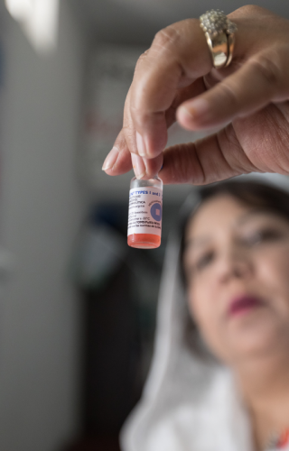 Tayyaba Gul, of the Rotary Club of Islamabad (Metropolitan), examines a vile of vaccine at the Resource Centre she established in Nowshera, Pakistan.