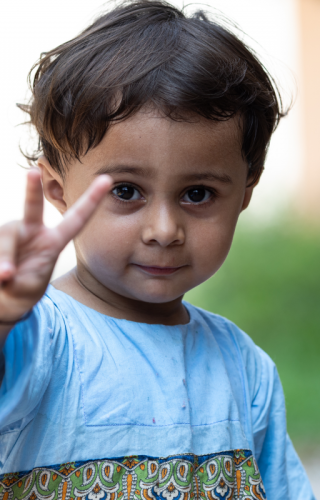 A child in Islamabad, Pakistan, holding up two fingers